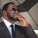 R&B singer R. Kelly covers his mouth as he speaks to members of his entourage as he leaves the Leighton Criminal Courts Building following a hearing on June 26, 2019, in Chicago.